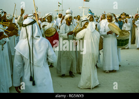 Dubai. Arab festeggiamenti nuziali con gli uomini nel tradizionale abito araba generalmente si diverte, canto, danza, sfilano in Emirato di Dubai in 1986 Foto Stock