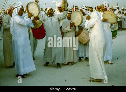 Dubai. Arab festeggiamenti nuziali con gli uomini nel tradizionale abito araba generalmente si diverte, canto, danza, sfilano in Emirato di Dubai in 1986 Foto Stock