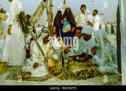 Dubai. Arab festeggiamenti nuziali con gli uomini nel tradizionale abito araba generalmente si diverte, canto, danza, sfilano in Emirato di Dubai in 1986 Foto Stock