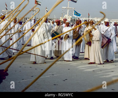 Dubai. Arab festeggiamenti nuziali con gli uomini nel tradizionale abito araba generalmente si diverte, canto, danza, sfilano in Emirato di Dubai in 1986 Foto Stock