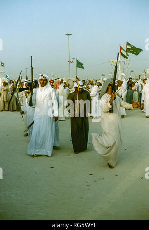 Dubai. Arab festeggiamenti nuziali con gli uomini nel tradizionale abito araba generalmente si diverte, canto, danza, sfilano in Emirato di Dubai in 1986 Foto Stock