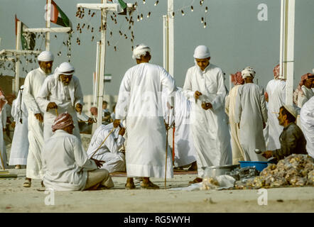 Dubai. Arab festeggiamenti nuziali con gli uomini nel tradizionale abito araba generalmente si diverte, canto, danza, sfilano in Emirato di Dubai in 1986 Foto Stock