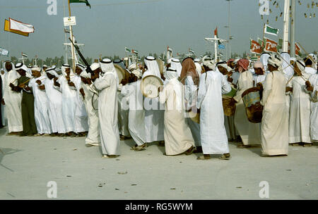 Dubai. Arab festeggiamenti nuziali con gli uomini nel tradizionale abito araba generalmente si diverte, canto, danza, sfilano in Emirato di Dubai in 1986 Foto Stock