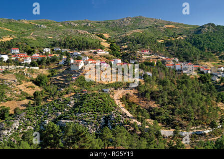 Vista del villaggio di montagna circondato da montagne verdi e rocce Foto Stock