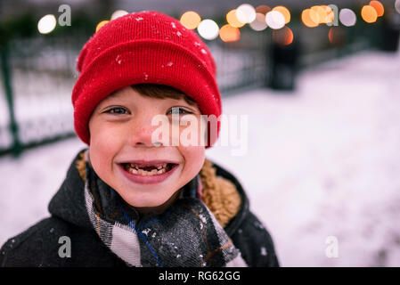 Ritratto di un ragazzo sorridente con denti mancanti in piedi nella neve, Stati Uniti Foto Stock