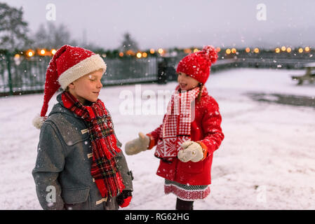 Due bambini che giocano sulla neve a Natale, Stati Uniti Foto Stock