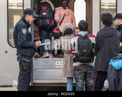 SID, SERBIA - Novembre 14, 2015: Croato poliziotti controllare i rifugiati, di salire a bordo di un treno per attraversare la Croazia Serbia frontiera a Sid il treno sta Foto Stock