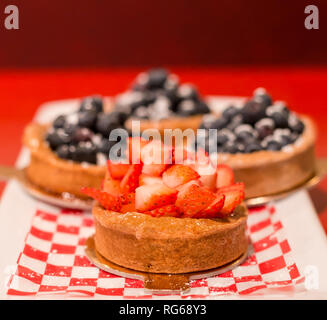 Crostata di fragole con crostate di mirtilli in background. Foto Stock