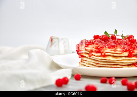 American pancake con la marmellata - berry, pallon di maggio, mirtillo rosso su sfondo grigio. Pancake fatti in casa con salsa di frutti di bosco e le foglie di menta. Sana colazione con prodotti freschi h Foto Stock