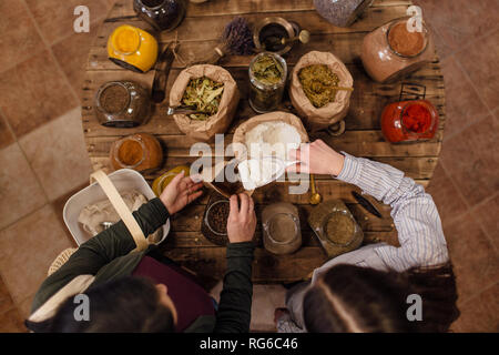 Angolo di alta vista di shop assistant mettere la farina nel sacchetto di carta per il cliente a rifiuti zero shop. Vista dall'alto. Foto Stock