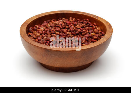 Essiccato sumac bacche nella ciotola di legno, isolato su sfondo bianco Foto Stock