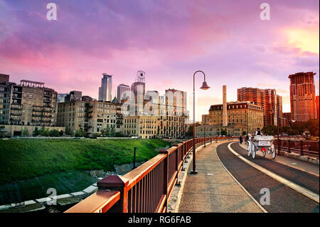 Una carrozza attraversa il centro storico arco in pietra ponte sopra il fiume Mississippi a Minneapolis, Minnesota. Foto Stock