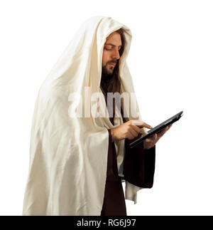 Gesù Cristo si legge la Sacra Bibbia con il tablet Foto Stock