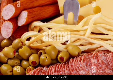 Assortimento di formaggi e olive e salsicce sul tavolo vista superiore, laici piatta Foto Stock