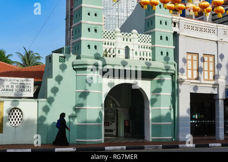 Una donna musulmana circa per entrare in Moschea Jamae in Chinatown, Singapore, le ombre delle lanterne cinesi appesa sopra la strada si vede sulla parete della moschea Foto Stock