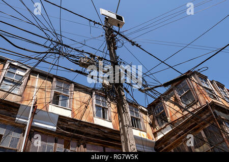 Un apparentemente aggrovigliati e disorganizzato di raccolta a cavi sospesi in una strada a Valparaiso, Cile. Foto Stock