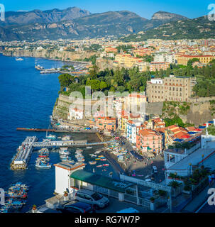 Una vista guardando oltre il porto di Marina Grande con il molo e barche in vacanza preferita di Sorrento, Italia Foto Stock