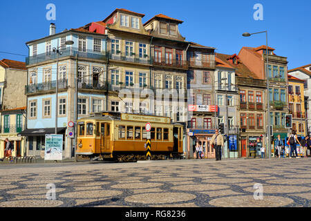 Basso angolo cattura del Porto tour il tram che passa attraverso la strada di città che mostra la tipica architettura portoghese. a Porto, Portogallo Foto Stock