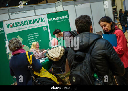 Berlino, Germania. 28 gen, 2019. Presso la borsa lavoro per i rifugiati e gli stranieri che cercano lavoro presso l'Estrel Hotel, visitatori parlare di un dipendente a un'applicazione stand di Volkssolidarität. La fiera è organizzata dall'Agenzia federale per l'occupazione e l'Estrel Hotel ed è destinato a rendere più agevole per gli immigrati con prospettive di soggiornare in Germania per trovare posti di lavoro e di formazione. Credito: Gregor Fischer/dpa/Alamy Live News Foto Stock