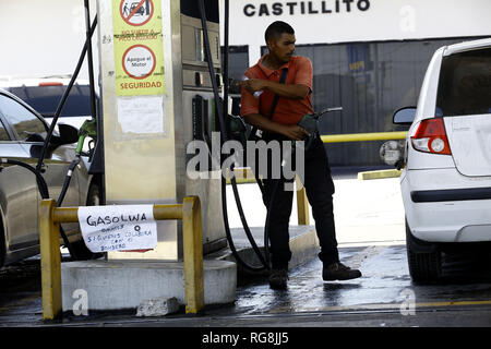 San Diego, Carabobo, Venezuela. 28 gen, 2019. Il 28 gennaio 2019. Presso il servizio Castillito stazione, Mauro Ramirez, un'isola operatore, ha deciso di mettere un avviso ai clienti dove egli offre la benzina per libera e chiede loro di collaborare con il ''vigile del fuoco'', dato il basso costo della benzina, spiegato in che modo egli guadagna più denaro di quanto il suo boss si rifiuta di pagare il suo stipendio poiché il carburante del margine di profitto non è sufficiente per coprire le spese. In San Diego comune della Stato Carabobo. Foto: Juan Carlos Hernandez Credito: Juan Carlos Hernandez/ZUMA filo/Alamy Live News Foto Stock