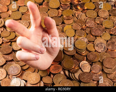 La mano che è fuori del mucchio di monete Foto Stock