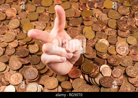 La mano che è fuori del mucchio di monete Foto Stock