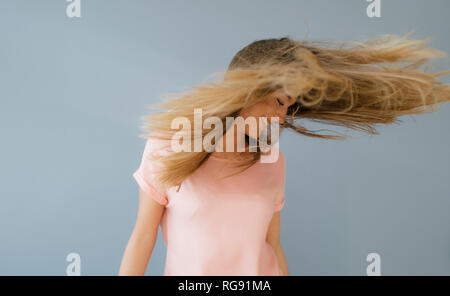 Ridendo giovane donna nel lanciare i suoi capelli Foto Stock