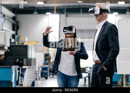 Proprietario di una donna in high tech enterprise, utilizzando gli occhiali VR Foto Stock