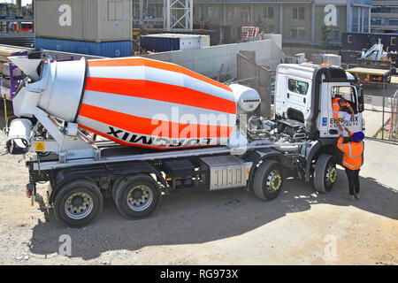 Euromix consegna camion Truck & inclinazione pilota al di fuori della cabina per ottenere i suoi documenti firmati da gatekeeper sulla costruzione dell'edificio sito Londra Inghilterra REGNO UNITO Foto Stock