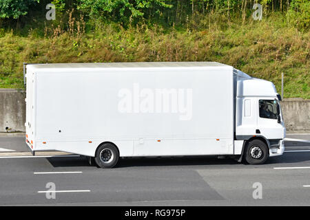 Vista laterale di un pulito senza contrassegno tutto bianco hgv autocarro Autocarro Furgone trasporto con cabina e driver senza alcuna pubblicità percorrendo l autostrada M25, England Regno Unito Foto Stock