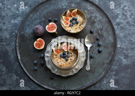 Bocce di porridge con spicchi di fichi, mirtilli e frutti di bosco essiccati Foto Stock