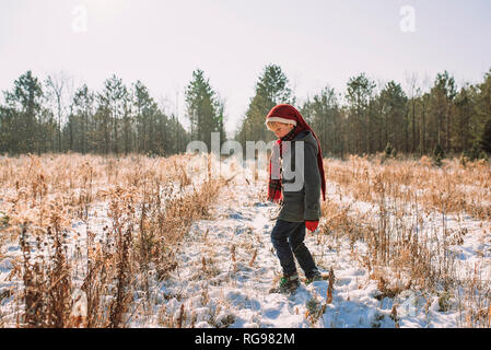 Ragazzo camminando in un campo in inverno, Stati Uniti Foto Stock