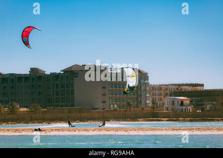 Egitto, Hurghada - 30 Novembre, 2017: due kitesurfisti tenendo la traversata aquiloni sul Mar Rosso poco profonda. La splendida vista del panorama Bungalows Aq Foto Stock