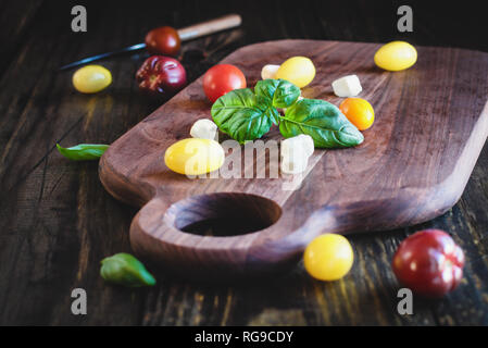 Fresco dal giardino di basilico e cimelio di pomodori con mozzarella per insalata caprese, cibo italiano e una sana dieta vegetariana concetto, oltre a r Foto Stock