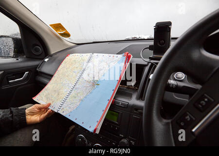 STONEHAVEN, aberdeenshire, Scozia, Regno Unito, 7 luglio 2017. La pianificazione del percorso con il Touring mappa durante un acquazzone torrenziale nel parcheggio a Stonehaven Foto Stock