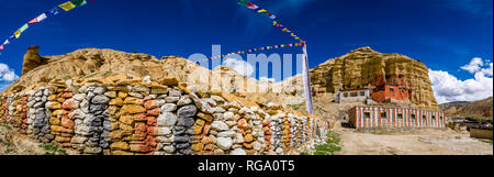 Vista panoramica sul monastero locale Nifuk Gompa, situato sotto una roccia, scuola del monastero e una parete di Mani con colorati bandiere di preghiera Foto Stock