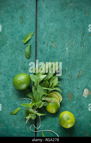 Mazzetto di menta e limes sul rustico sfondo di legno Foto Stock