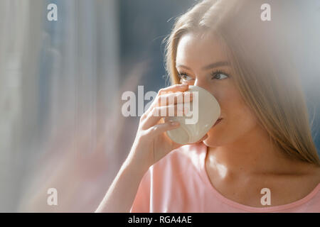 Giovane donna bere tazza di caffè Foto Stock