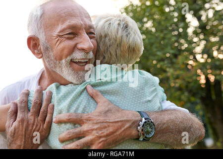 Felice coppia senior abbracciando all'aperto Foto Stock