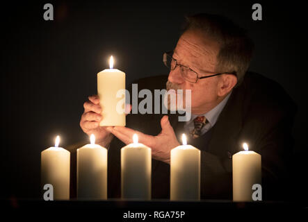 Superstite dell' Olocausto Martin luci di poppa candele per contrassegnare Memoriale Nazionale dell'olocausto del giorno avanti di un olocausto e scampati al genocidio evento all'Eastwood Park Theatre di Giffnock, East Renfrewshire. Foto Stock