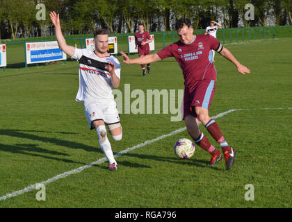 Cardiff, Regno Unito. Il 18 aprile 2018. Pontypridd Town FC vs AFC porth fixture di RSU Sports Park. Porth capitano Alex Adshead tussles con Pontypridd Foto Stock
