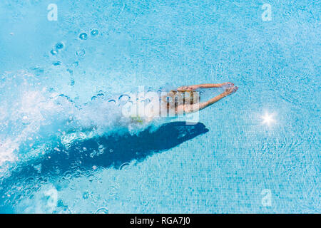 Spagna, provincia di Malaga, Mondron, donna tuffarsi in piscina la creazione di bolle Foto Stock
