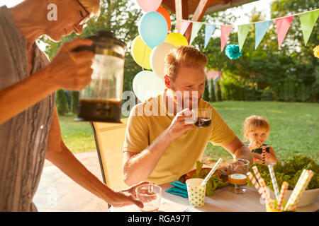 Donna che serve caffè su un party in giardino Foto Stock