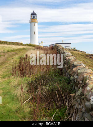 Parete di roccia che conduce al promontorio di Galloway lighthouse in Dumfries and Galloway, Scotland, Regno Unito sotto un cielo blu con nuvole bianche Foto Stock