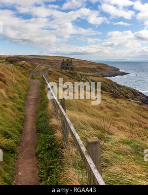 Cui il Dunskey castello arroccato su una scogliera che si affaccia sul mare vicino a Portpatrick, Scotland, Regno Unito sotto un cielo drammatico Foto Stock