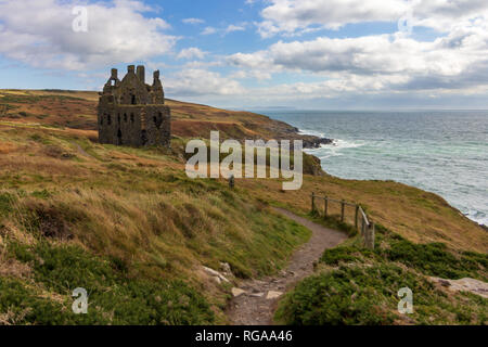 Cui il Dunskey castello arroccato su una scogliera che si affaccia sul mare vicino a Portpatrick, Scotland, Regno Unito sotto un cielo drammatico Foto Stock