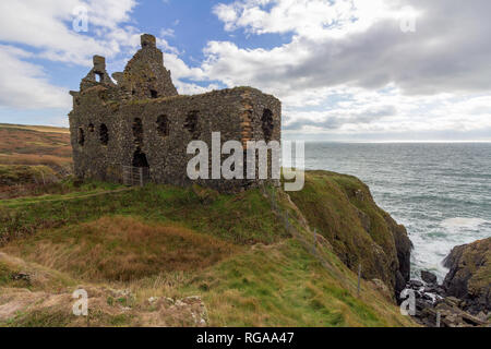 Cui il Dunskey castello arroccato su una scogliera che si affaccia sul mare vicino a Portpatrick, Scotland, Regno Unito sotto un cielo drammatico Foto Stock