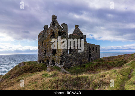 Cui il Dunskey castello arroccato su una scogliera che si affaccia sul mare vicino a Portpatrick, Scotland, Regno Unito sotto un cielo drammatico Foto Stock