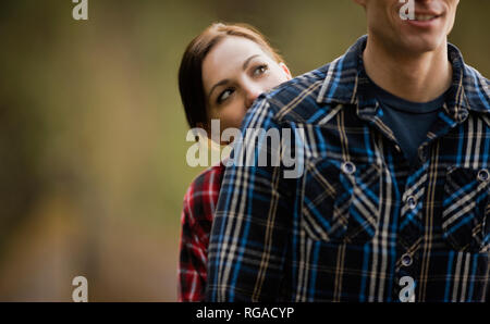 La donna si nasconde dietro il ragazzo indossa plaid shirt. Foto Stock