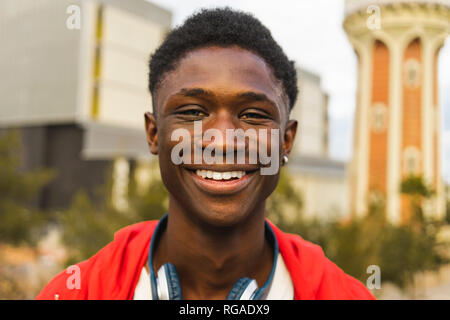 Giovane uomo nero con le cuffie, sorridente, ritratto Foto Stock